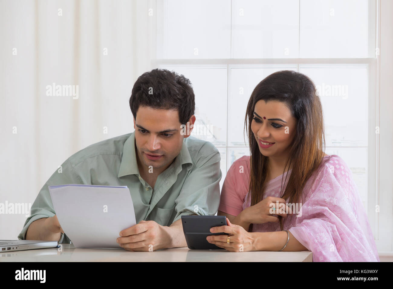 Couple calculating home finances using calculator Stock Photo