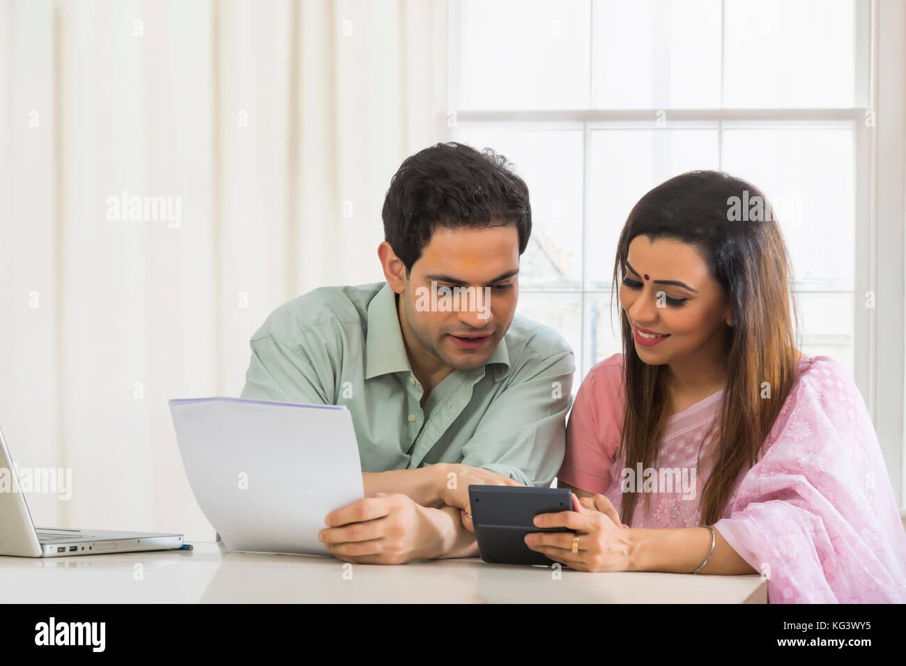 Couple calculating home finances using calculator Stock Photo