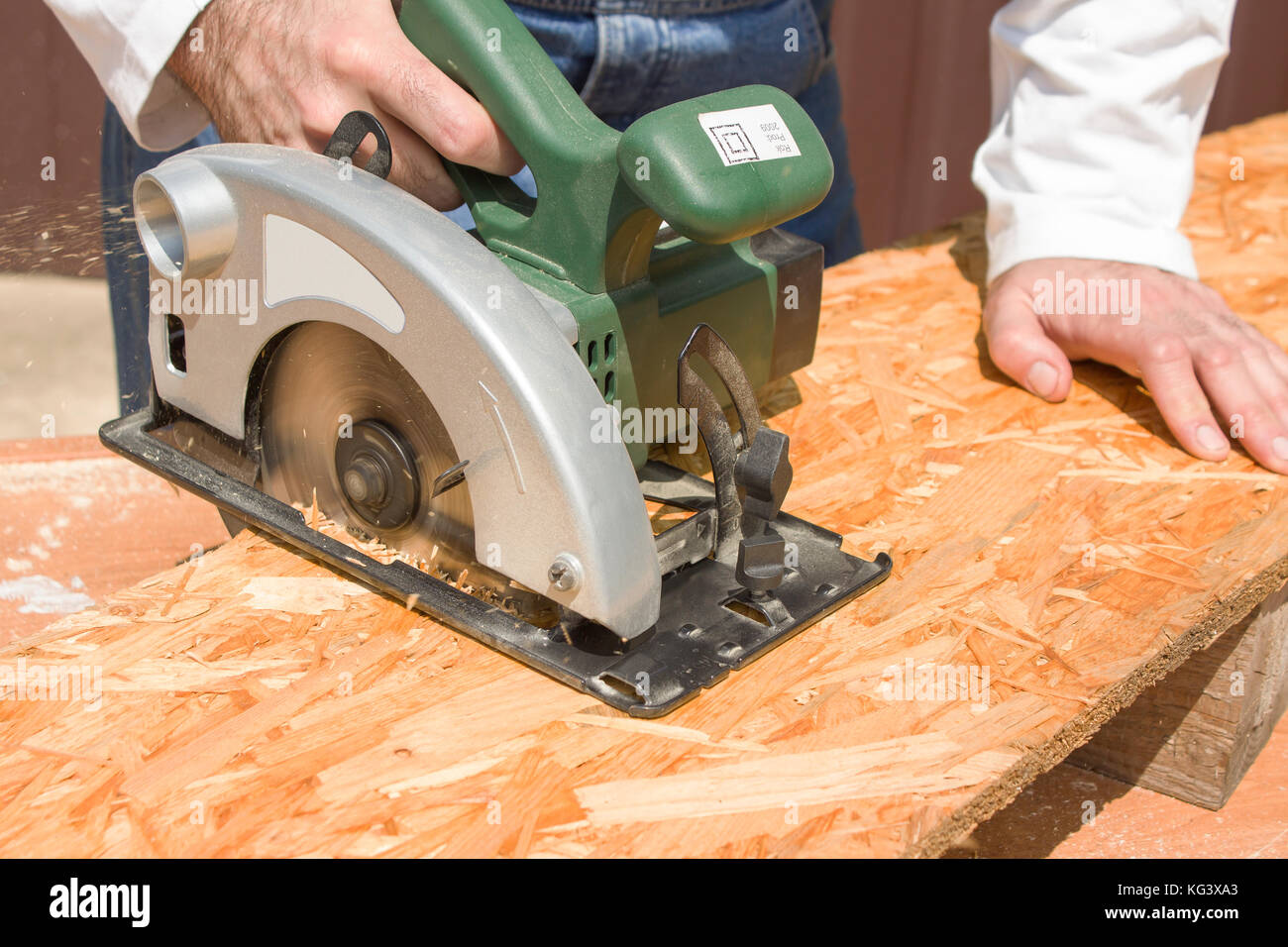 The carpenter cuts the board with a manual electric saw. Construction