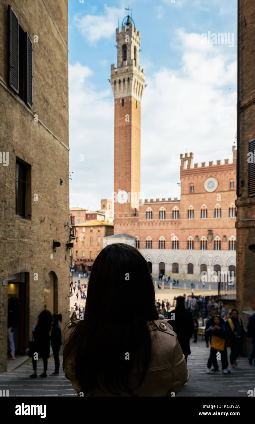 Tourist admires the Piazza del Campo medieval square in Siena, Tuscany, Italy Stock Photo