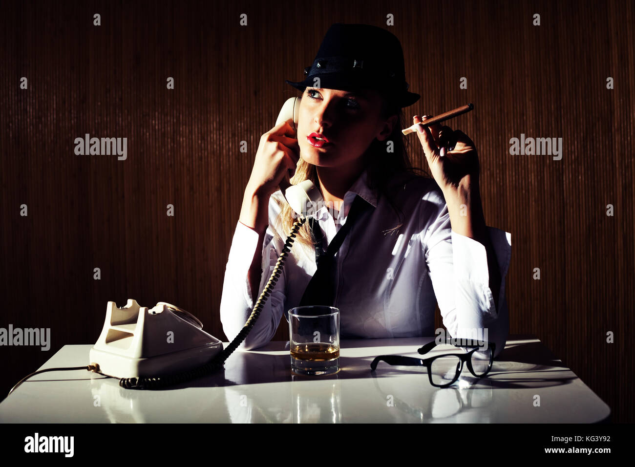 Retro styled businesswoman smoking cigar and talking on telephone. Stock Photo