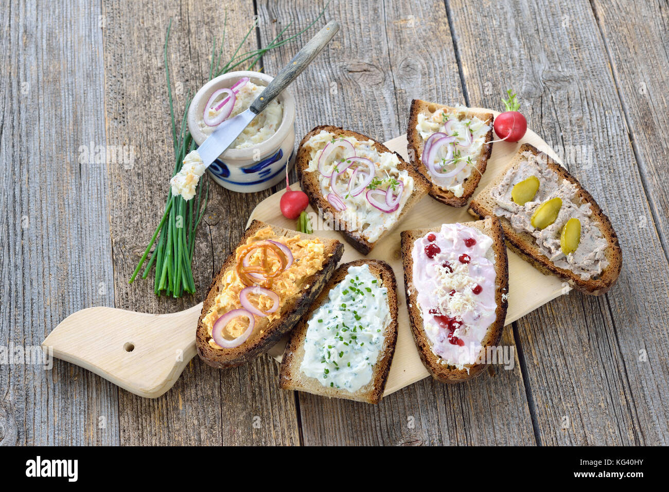 Hearty snack with different kinds of spreads on farmhouse bread served on an old wooden table Stock Photo