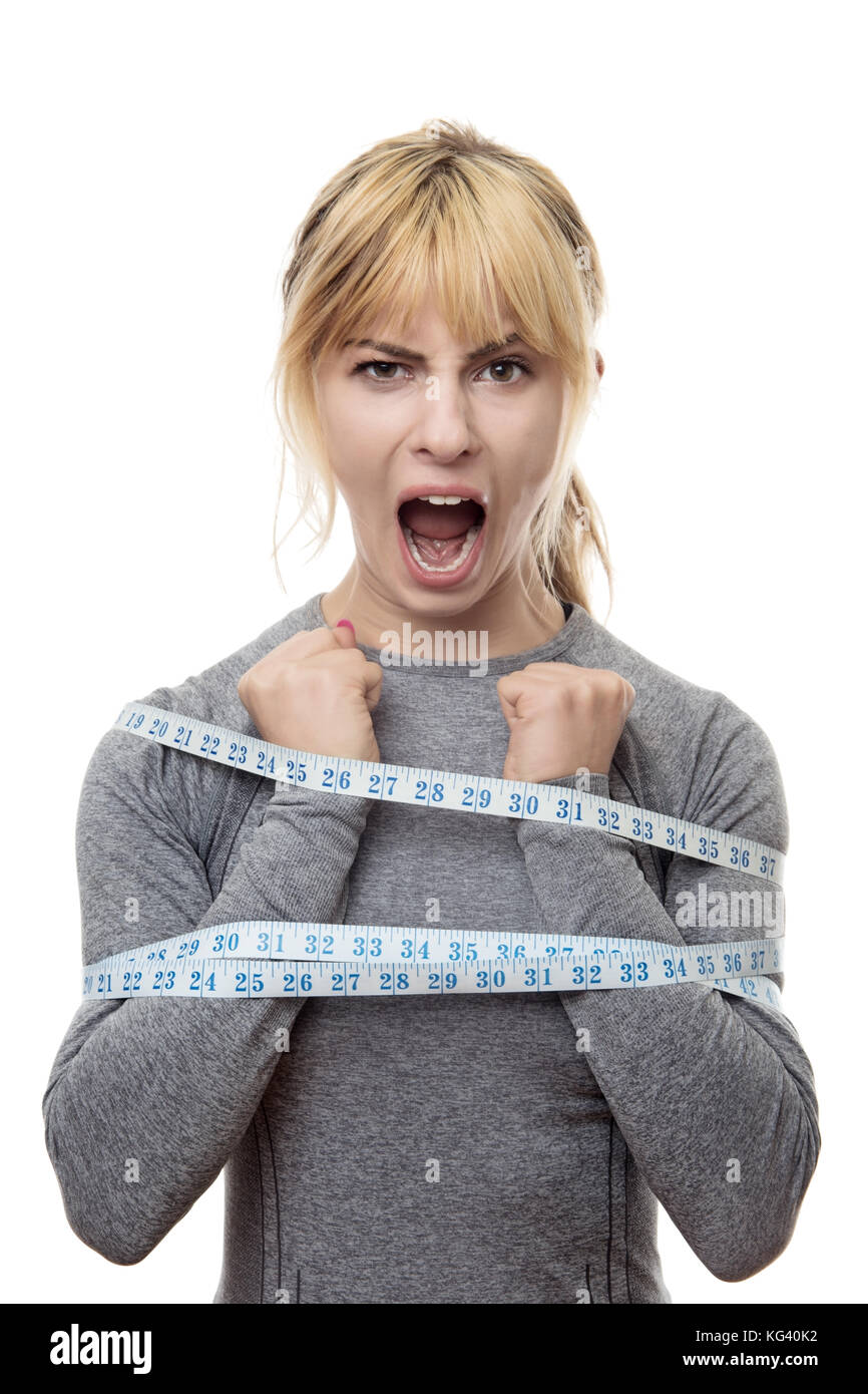 blond haired woman with a tape measure around her trying to break free from your restraints Stock Photo