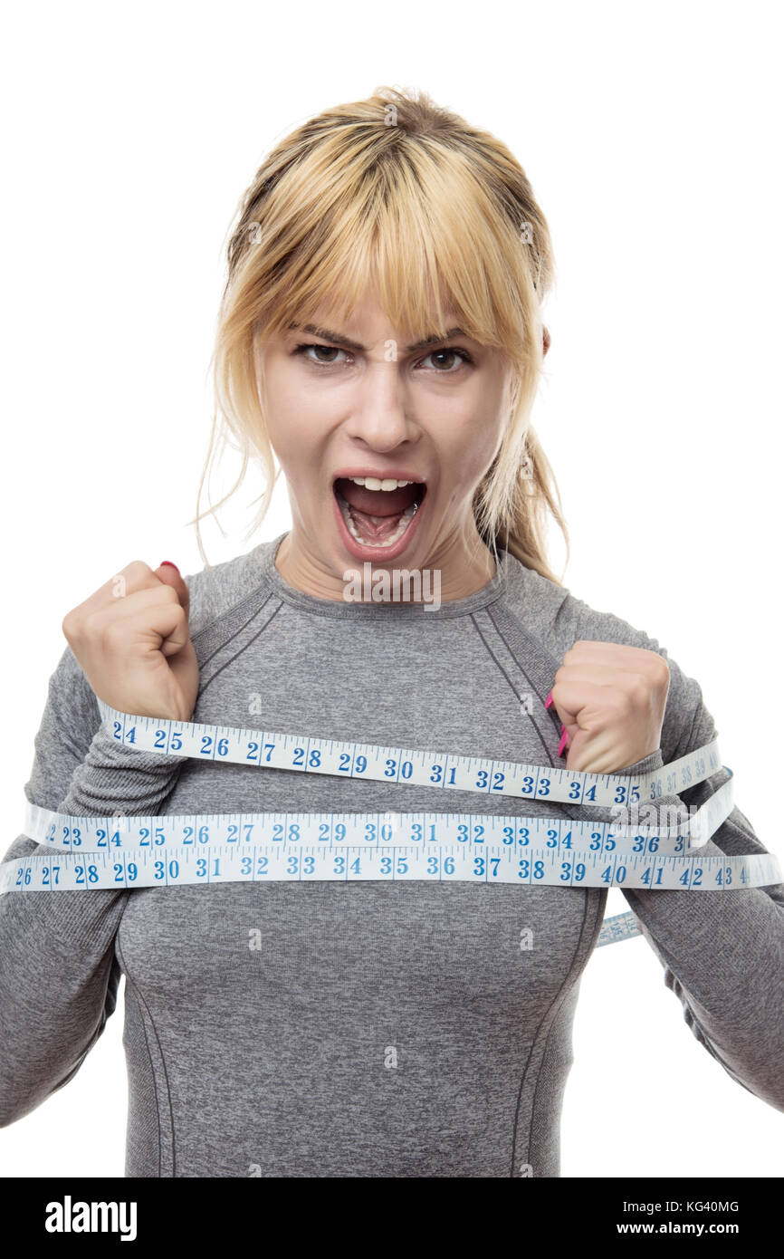 blond haired woman with a tape measure around her trying to break free from your restraints Stock Photo