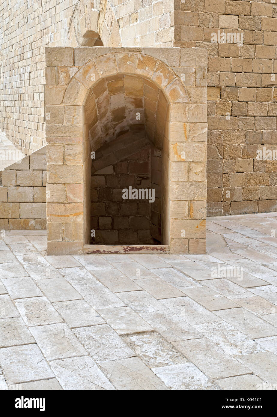 Ancient crypt entrance, bricks stone wall and tiled stone floor beside Kayet bay castle, Alexandria, Egypt Stock Photo