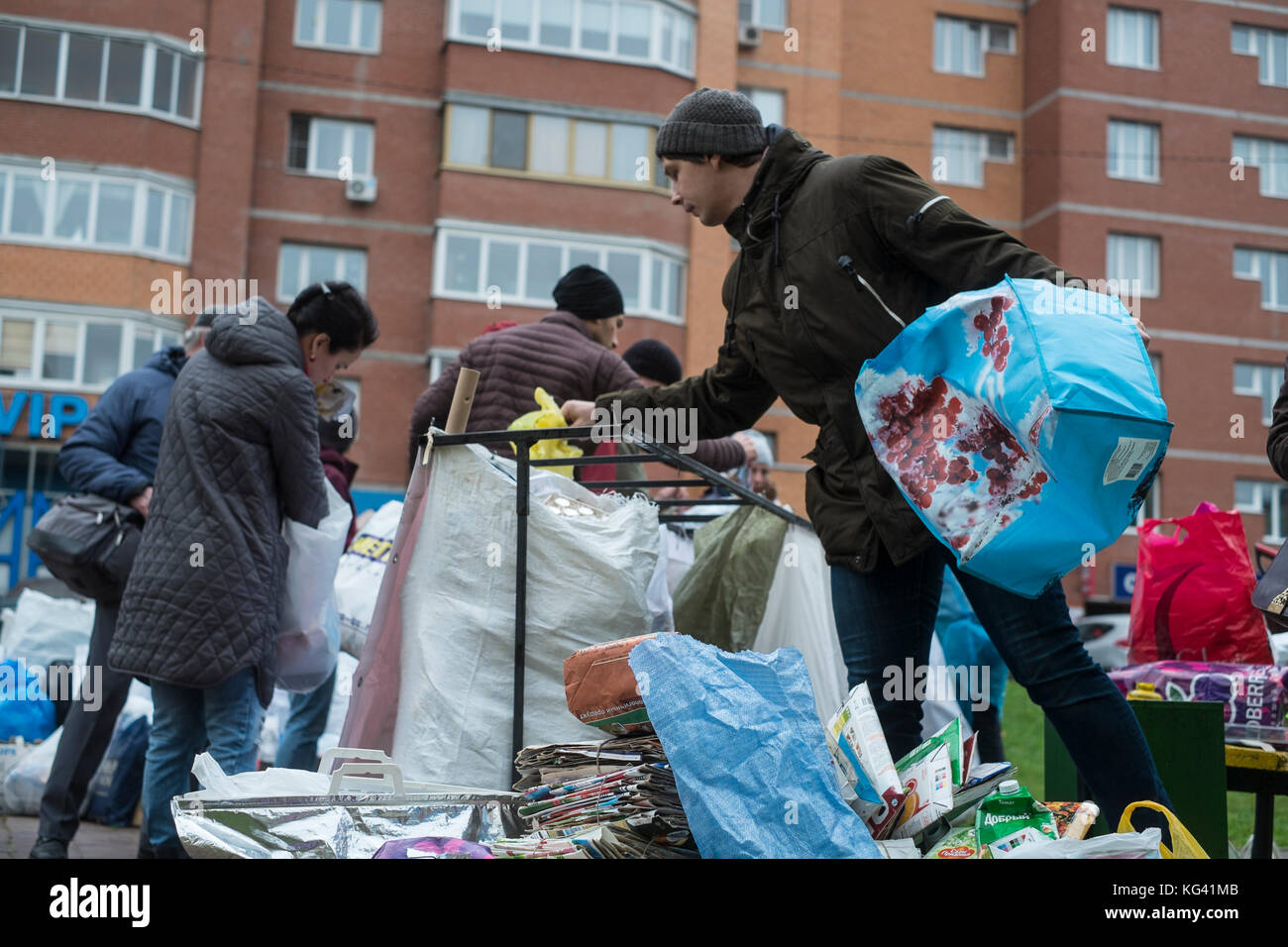 Volunteers collect household waste for recycling in a square in the town of Zheleznodorozhny, Moscow province, Russia. Local inhabitants have sorted their waste in advance at home in preceding weeks and can leave it in separate bags or containers here, for further transportation and recycling elsewhere. For now, the volunteers come here once a month, but the idea gains popularity. Waste sorting is still uncommon in Russia, where some ninety percent of household waste ends up at huge, open rubbish dumps. Stock Photo