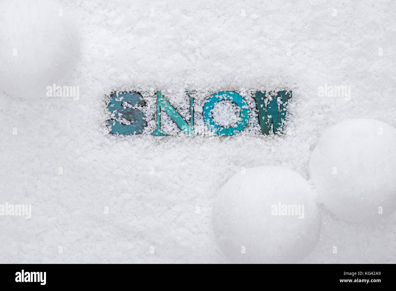 The word SNOW made from wooded letterpress letters on a snow background Stock Photo