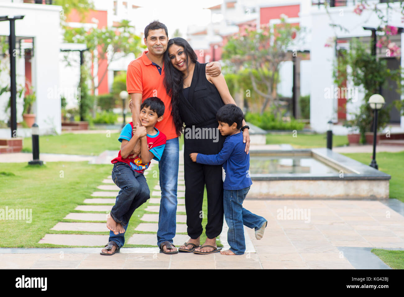 Happy family standing outside their house and neighbourhood. Stock Photo