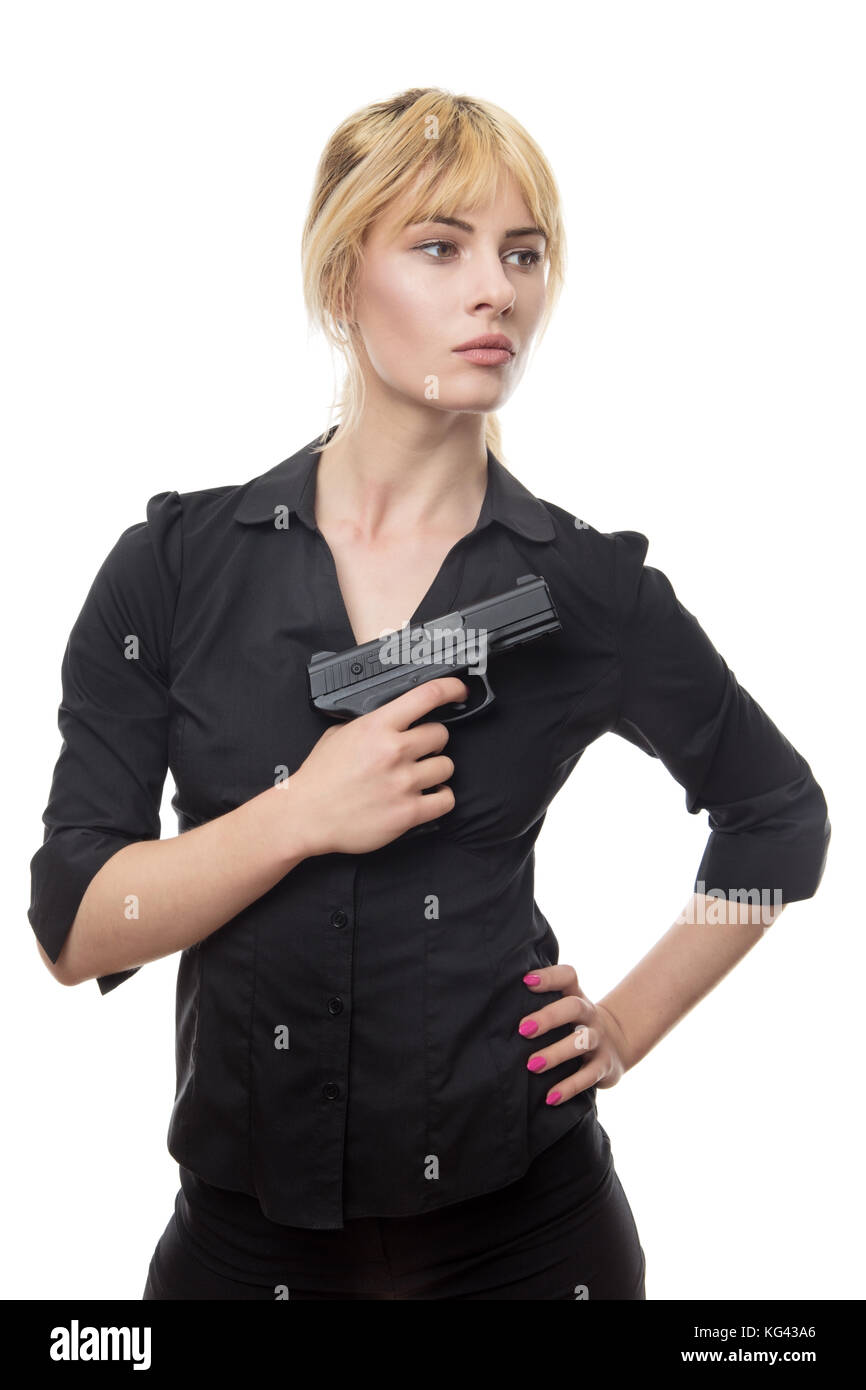 blonde haired business woman holding a gun up to her chest Stock Photo