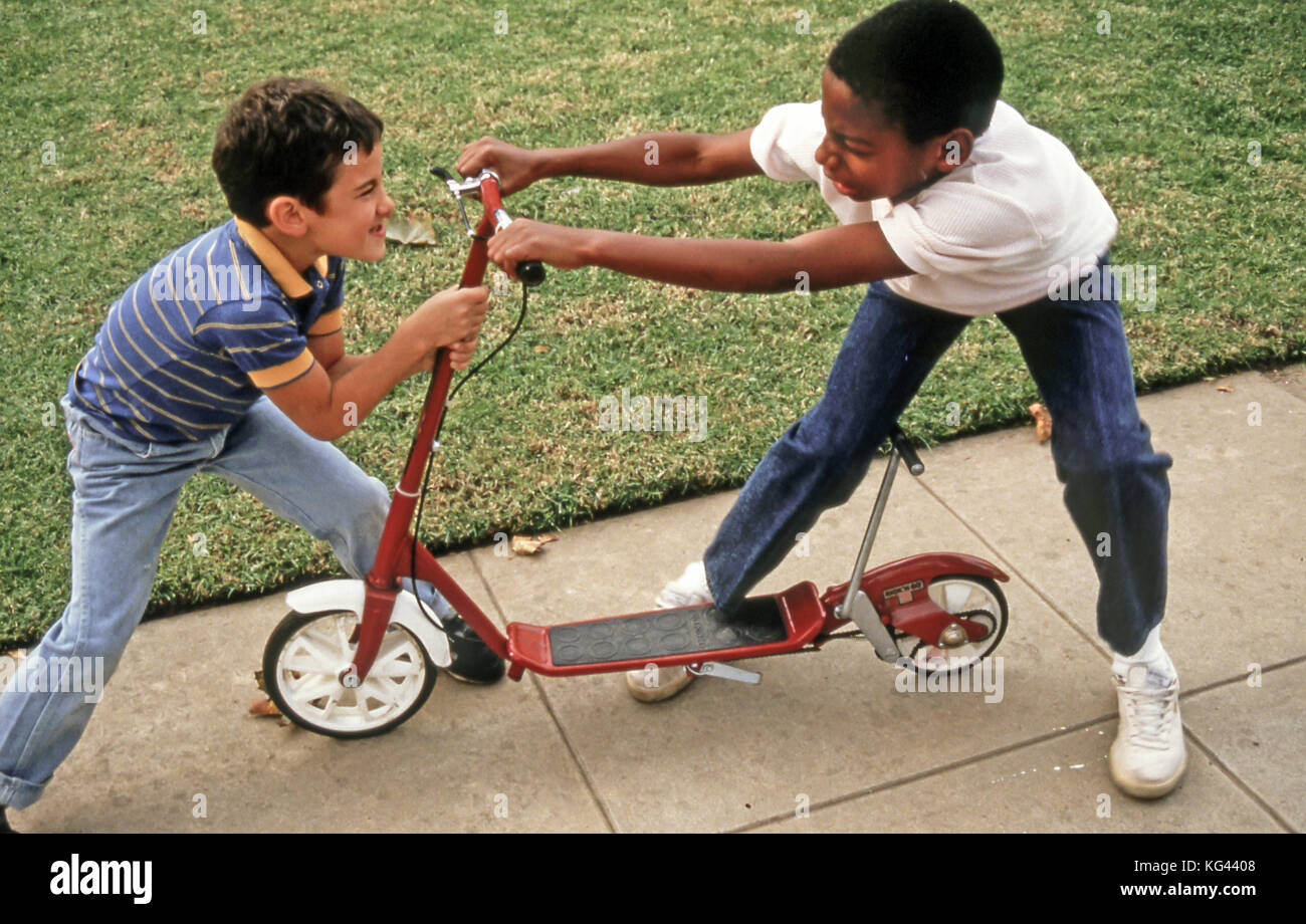 Children fighting Child taking toy away from another boy Two boys struggling over possession of scooter  MR  © Myrleen Pearson Stock Photo