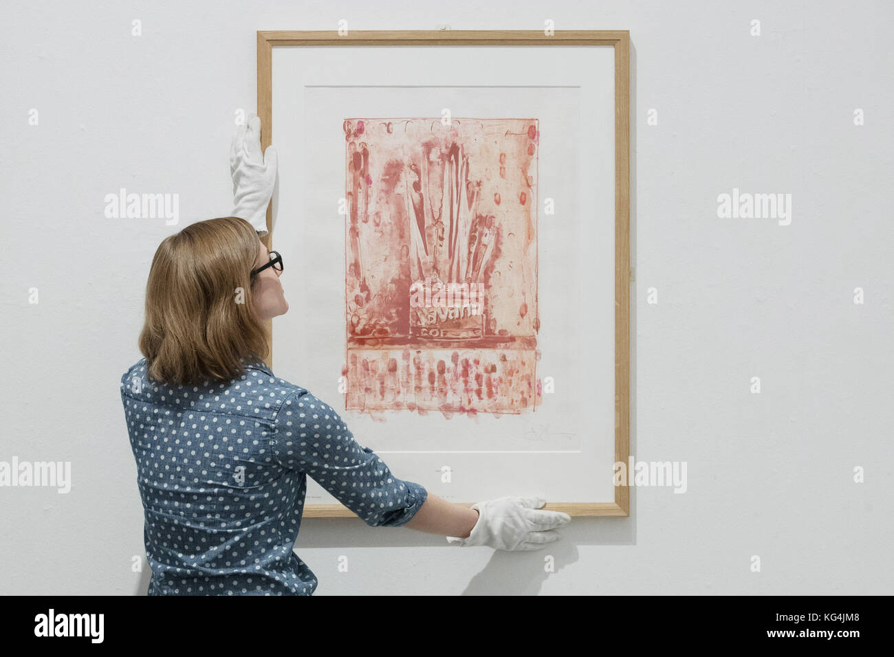 Emalee Beddoes-Davis museum curator adjusts Jasper Johns, Savarin 3 (red), 1978, on display at the Worcester City Art Gallery and Museum's Warhol to Walker: American prints from pop art to today exhibition. Stock Photo