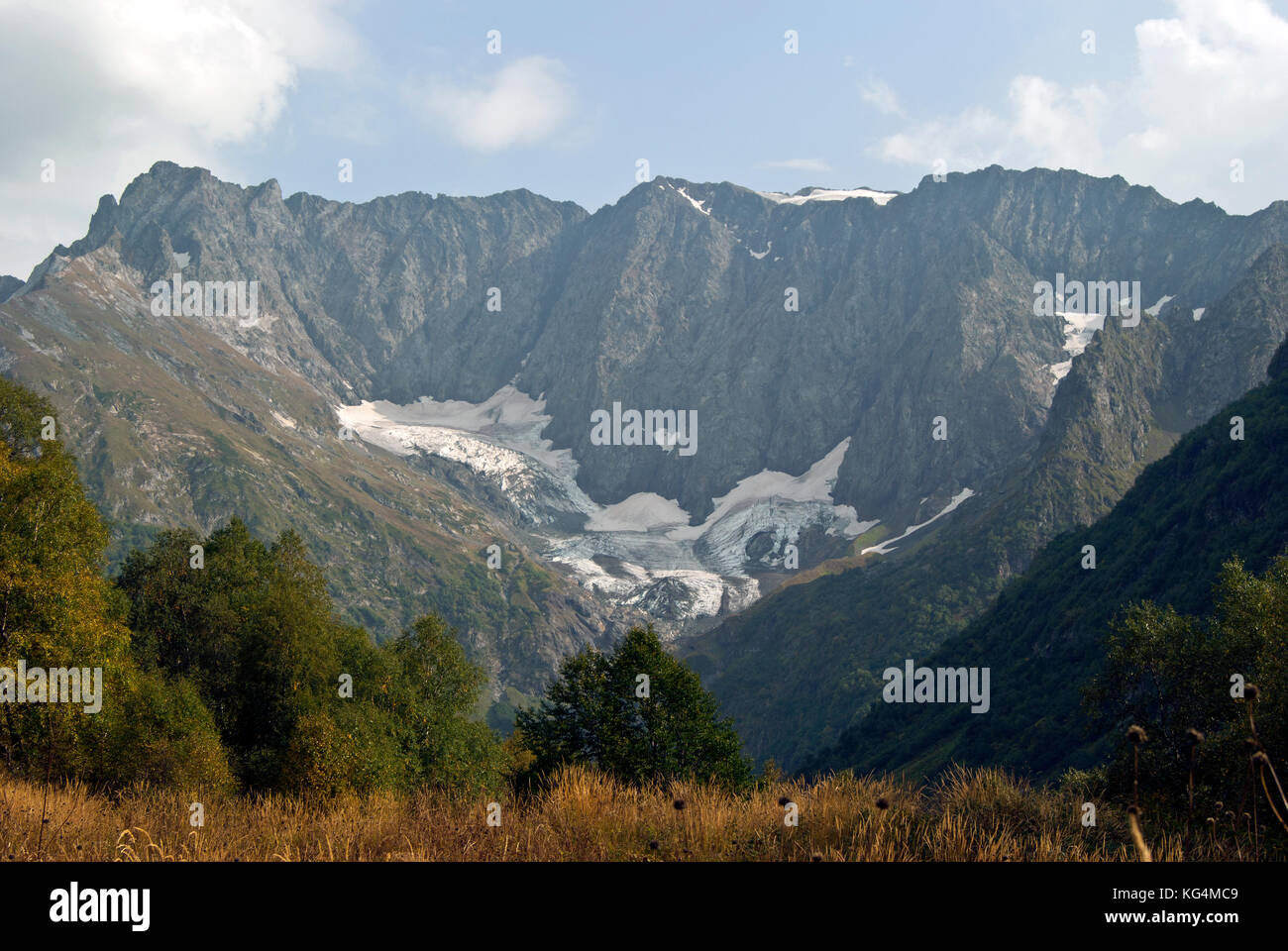 View from the autumn glade on a melting glacier in the Caucasus Mountains. Stock Photo
