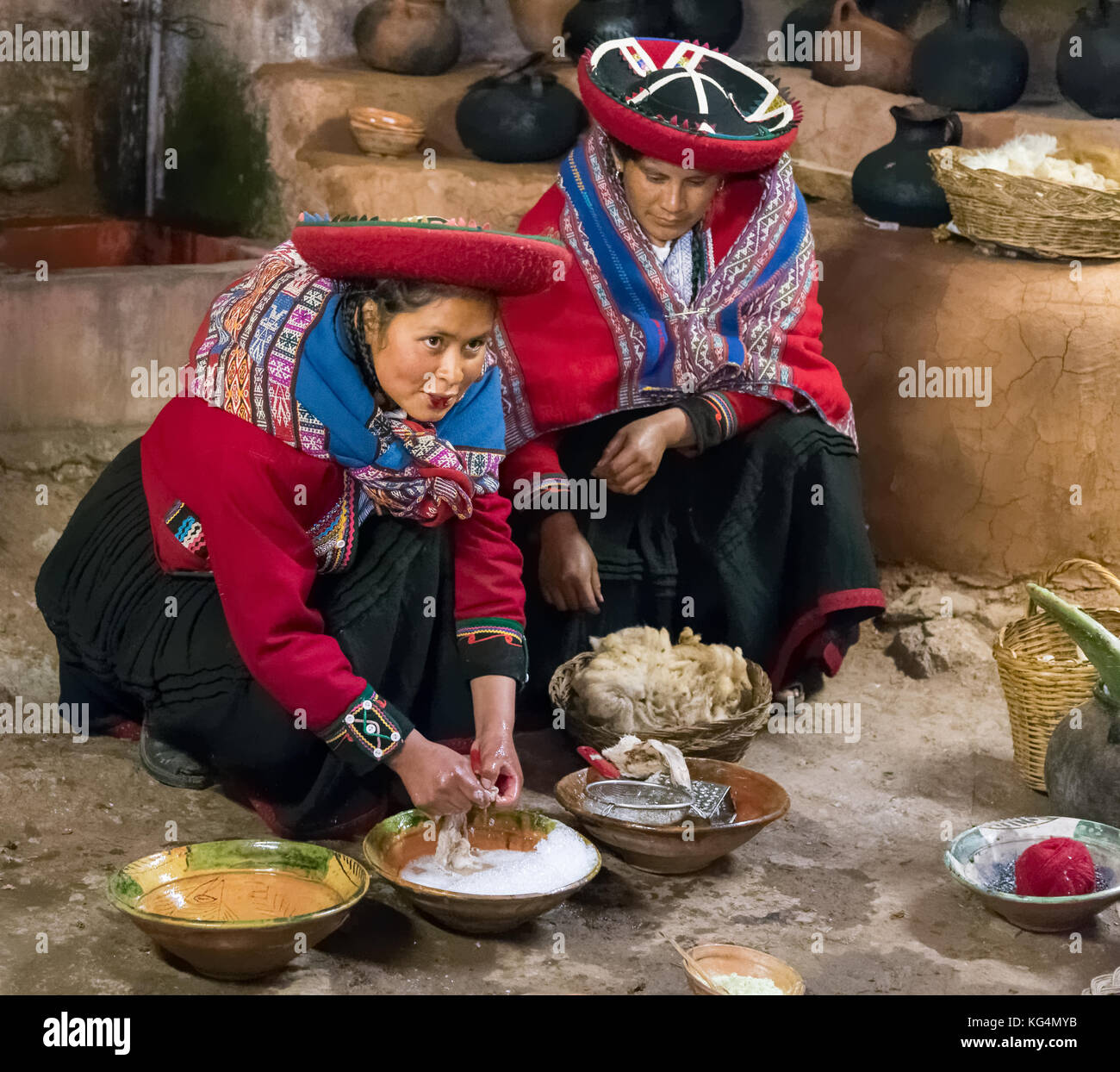 Women in traditional Peruvian clothes use natural dyes for Alpaca and Llama wool near Cusco, Peru Stock Photo