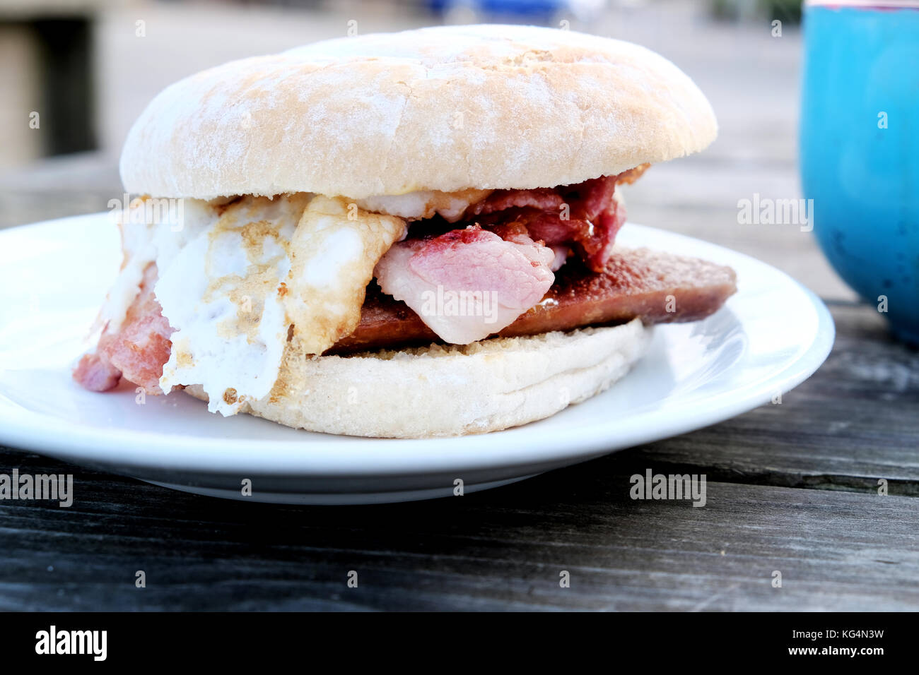 A tasty, mouth watering, breakfast bap made up of Sausage, bacon and egg bought from an outdoor café in Bristol, England, UK Stock Photo