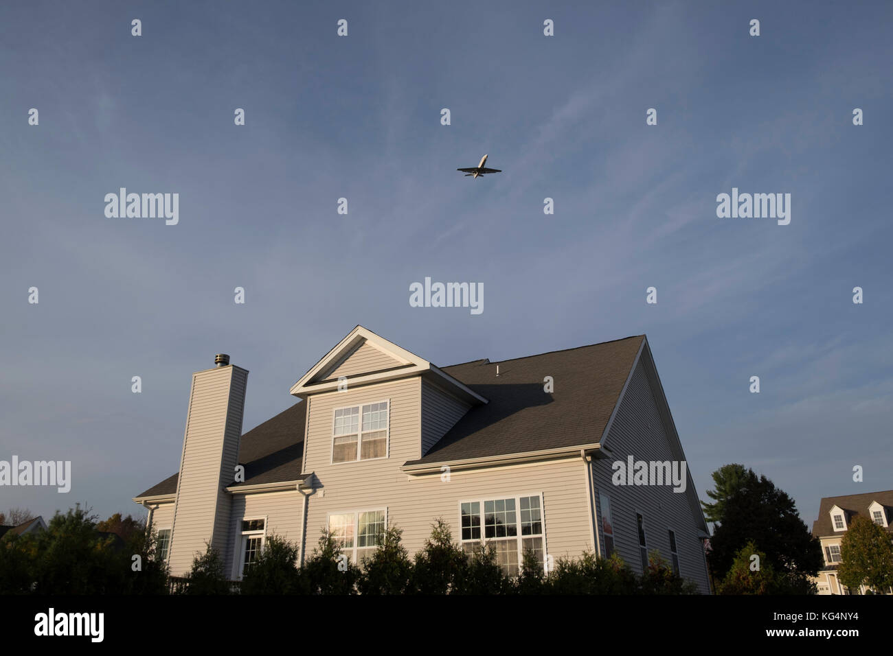 Plane flying over the house Stock Photo