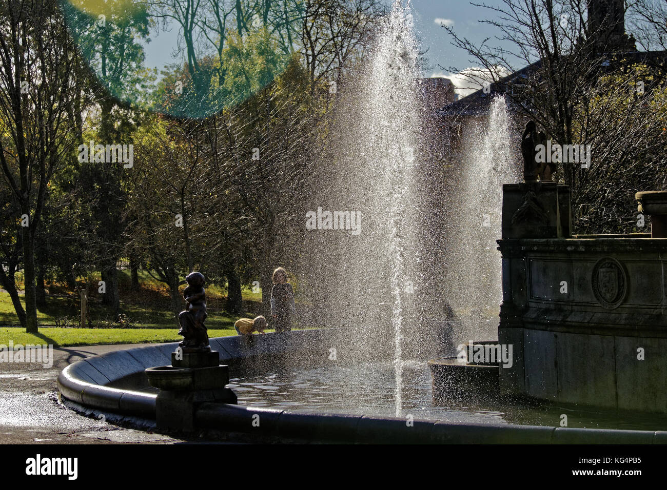 sunny day  boy children enjoying Kelvingrove Park Stewart Memorial Fountain Stock Photo