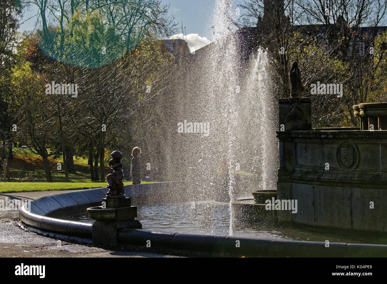 sunny day  boy children enjoying Kelvingrove Park Stewart Memorial Fountain Stock Photo