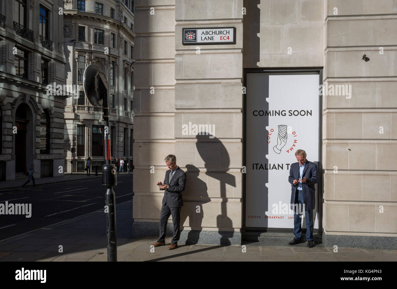 City businessmen check for messages and use social media on the corner of King William Street and Abchurch Lane EC4, on 27th October 2017, in the City of London, England. Stock Photo