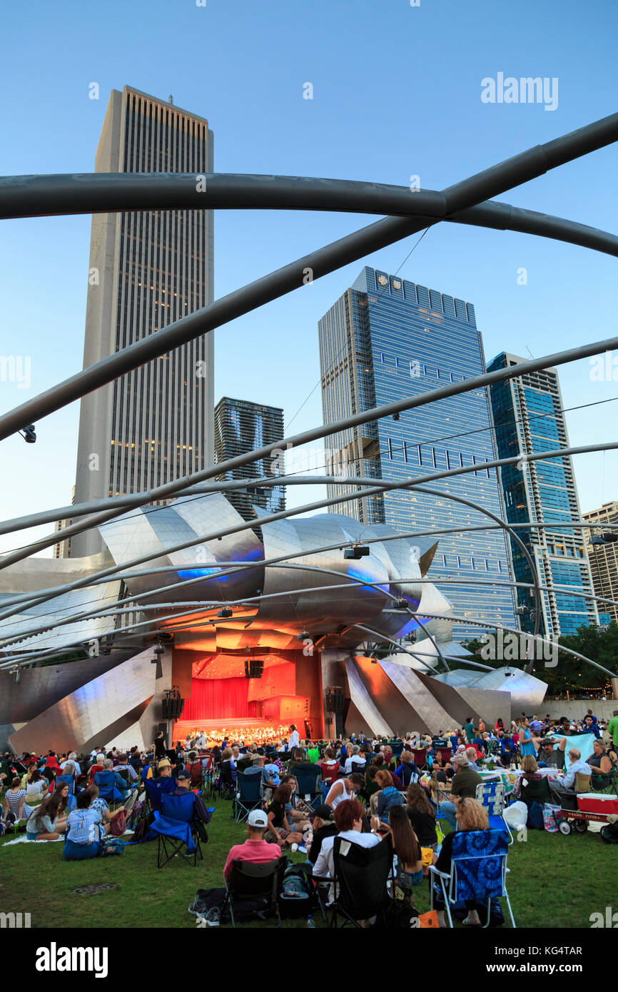Millennium Park, crowd at Grant Park Symphony  the Jay Pritzker Pavilion, a bandshell designed by Frank Gehry, skyscrapers of the downtown on the back Stock Photo