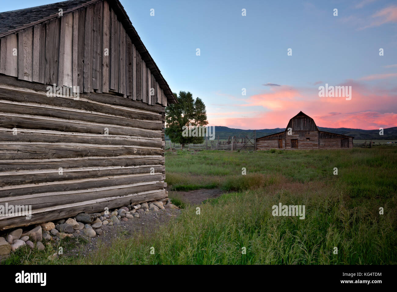 WY02542-00...WYOMING - Sunset over an old log structures at a homestead along Mormon Row in Grand Teton National Park. Stock Photo