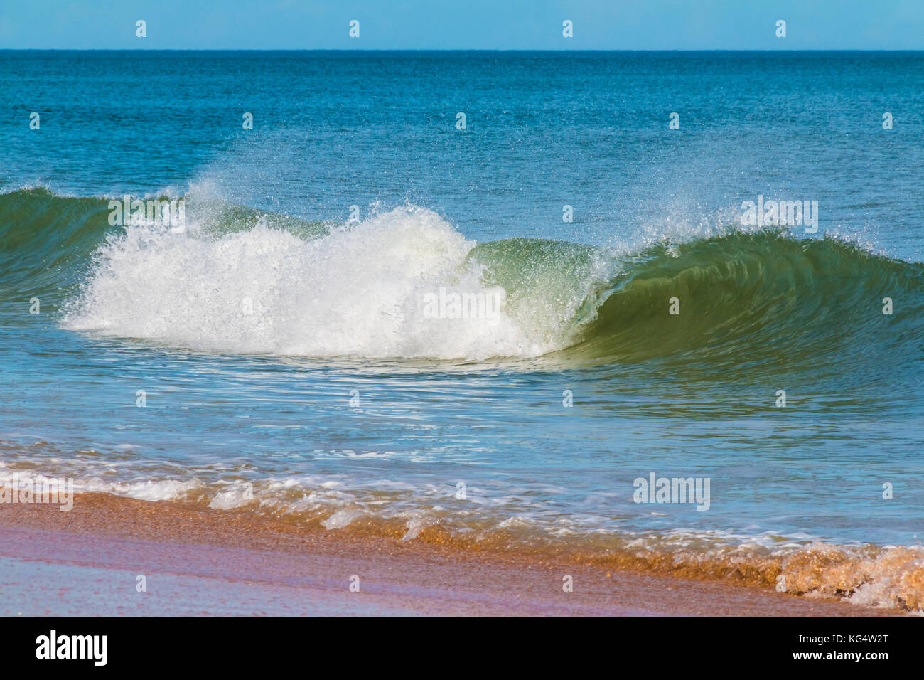 The surf on the sand shore and waves in the ocean in sunny hot day Stock Photo