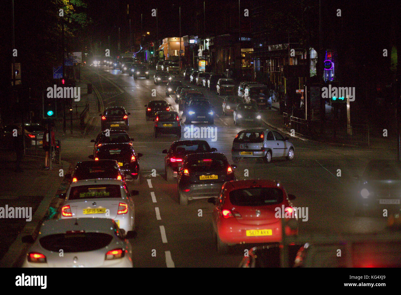 great western road at byres road botanics botanical gardens glasgow nighttime traffic cars and buses red lights shadows Stock Photo