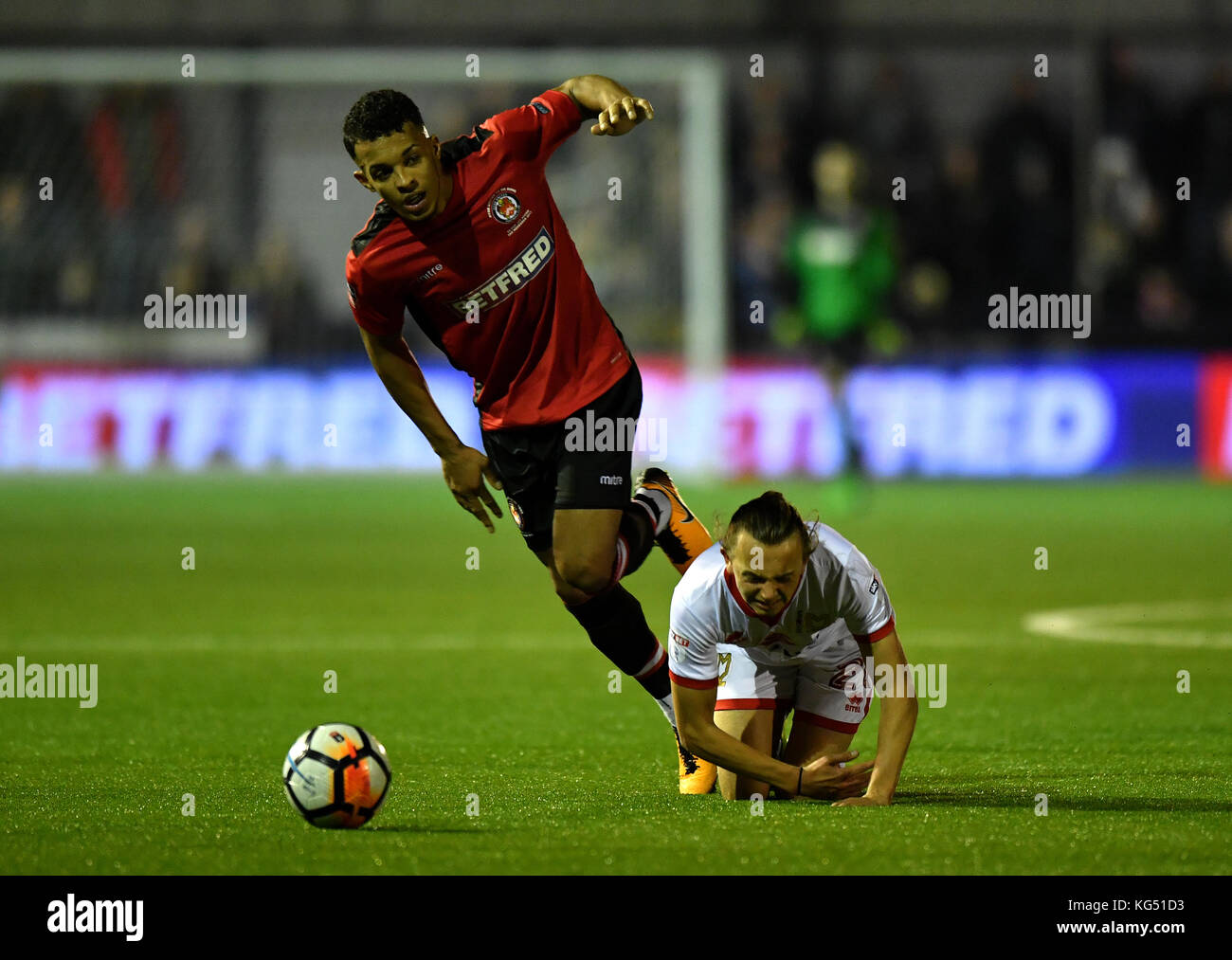 Hyde FC's Kyle Harrison (left) and MK Dons' Aidan Nesbitt battle for the ball during the Emirates FA Cup, first round match at Ewen Fields, Hyde. PRESS ASSOCIATION Photo. Picture date: Friday November 3, 2017. See PA story SOCCER Hyde. Photo credit should read: Anthony Devlin/PA Wire. RESTRICTIONS: EDITORIAL USE ONLY No use with unauthorised audio, video, data, fixture lists, club/league logos or 'live' services. Online in-match use limited to 75 images, no video emulation. No use in betting, games or single club/league/player publications. Stock Photo