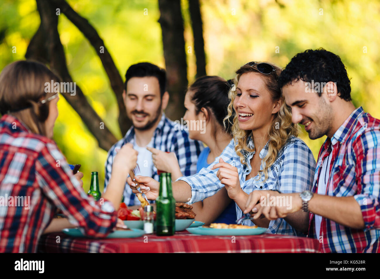 Group of happy people eating food outdoors Stock Photo