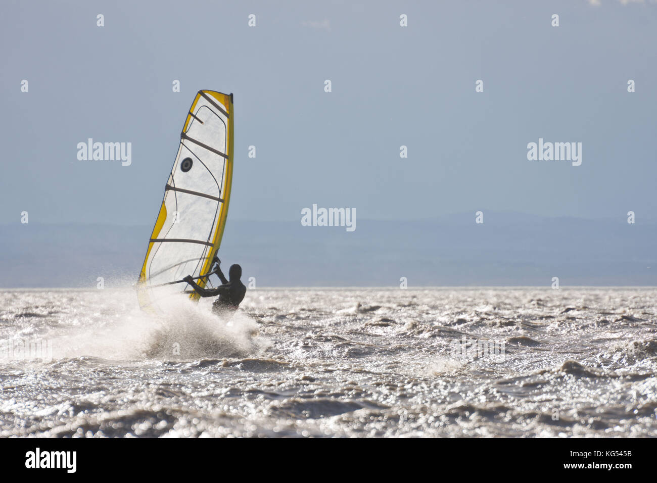 Windsurfer in a storm surfing up to the horizon. Stock Photo