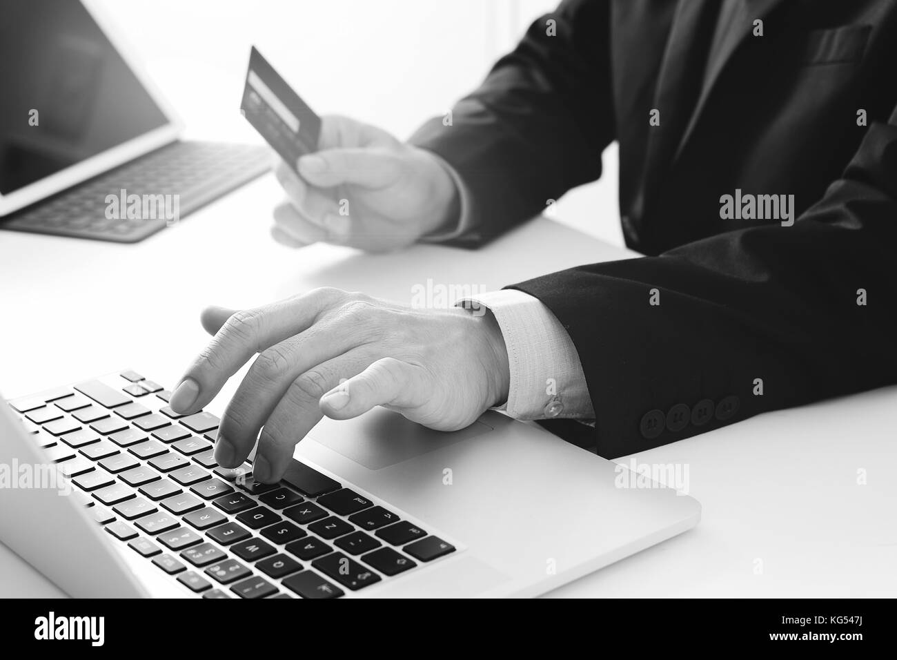 businessman making credit card purchase online with laptop computer on modern desk ,black and white Stock Photo