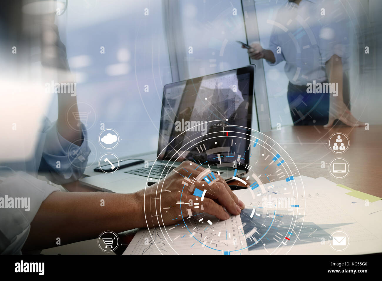 Hands of businessman using mobile phone in modern office with laptop and digital tablet computer in finance team meeting with VR icon diagram Stock Photo