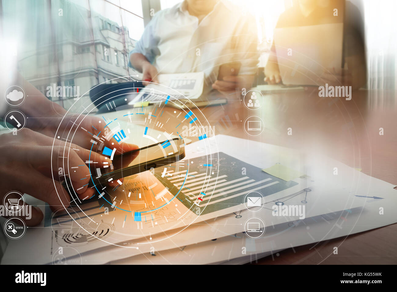 Hands of businessman using mobile phone in modern office with laptop and digital tablet computer in team meeting with VR icon diagram Stock Photo