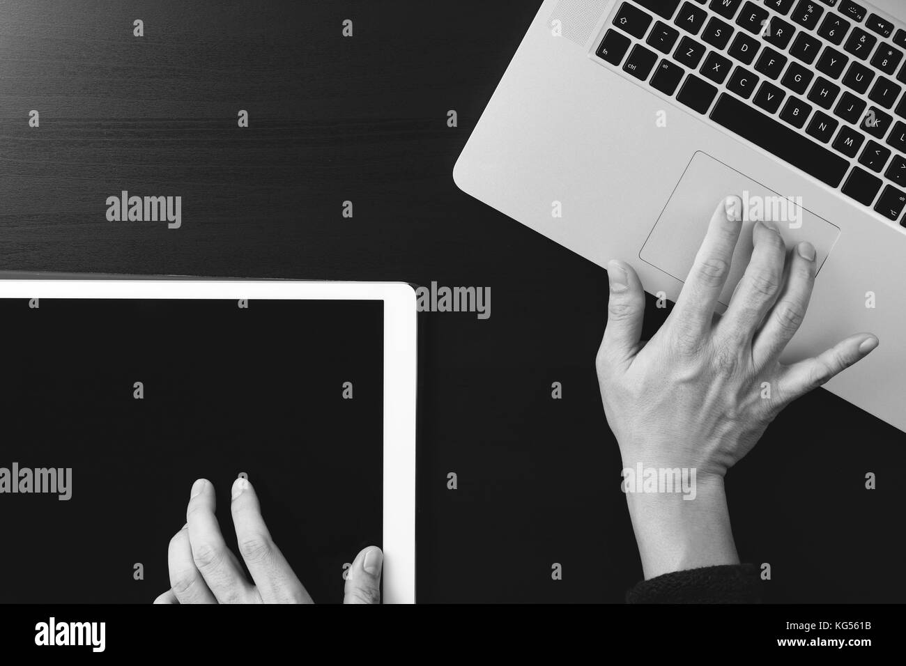 cyber security internet and networking concept.Businessman hand working with  laptop computer and digital tablet background,black and white Stock Photo