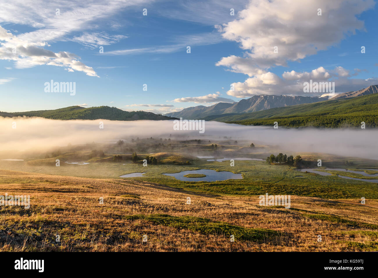 A picturesque landscape with mountains, beautiful mist over lakes ...
