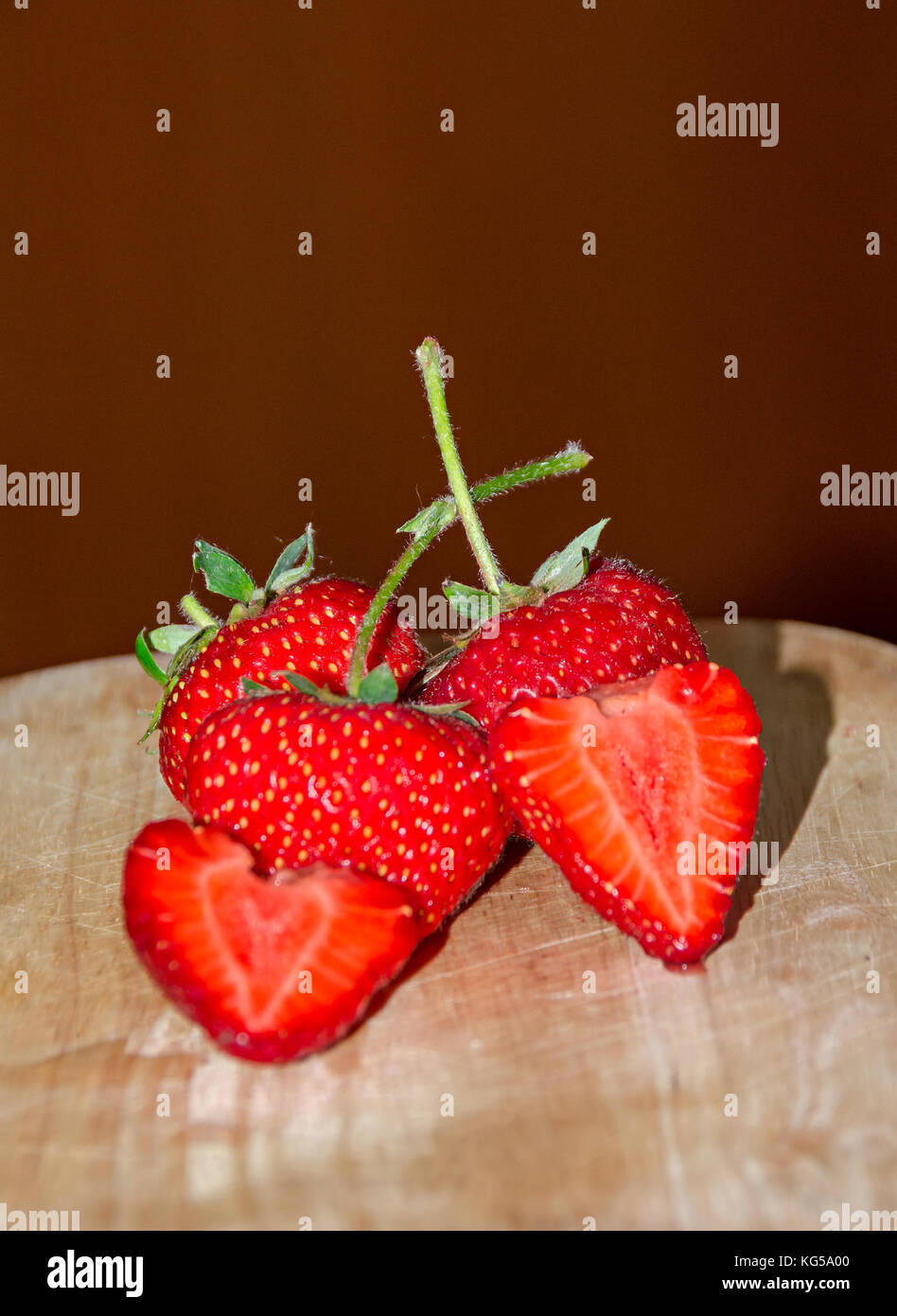 Red strawberries fruits and half strawberry rustic wood background ...