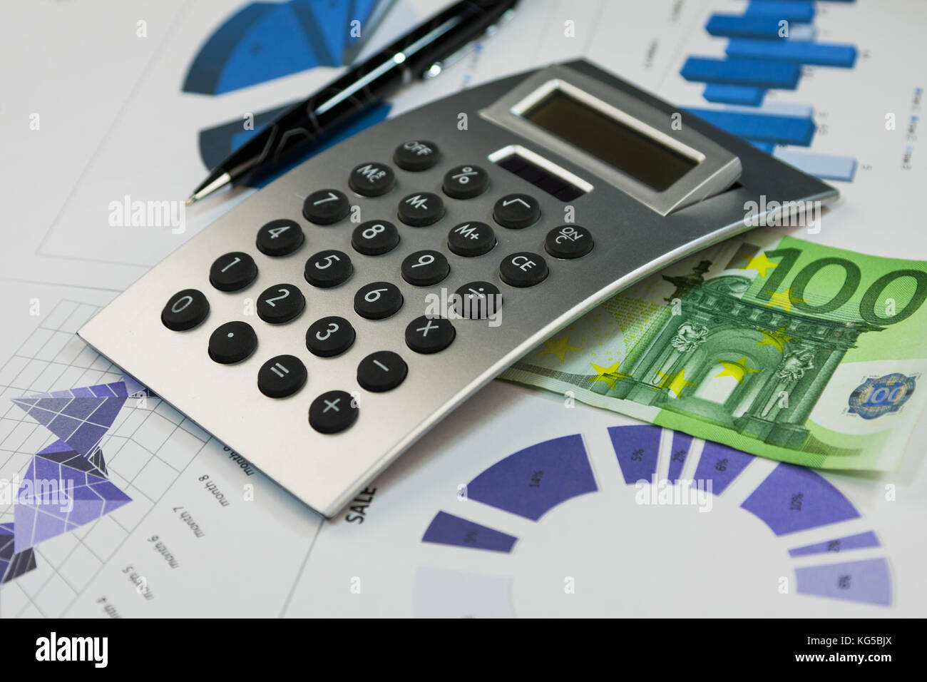 Calculator, one hundred euros and a pen lying on the diagrams. Business background Stock Photo