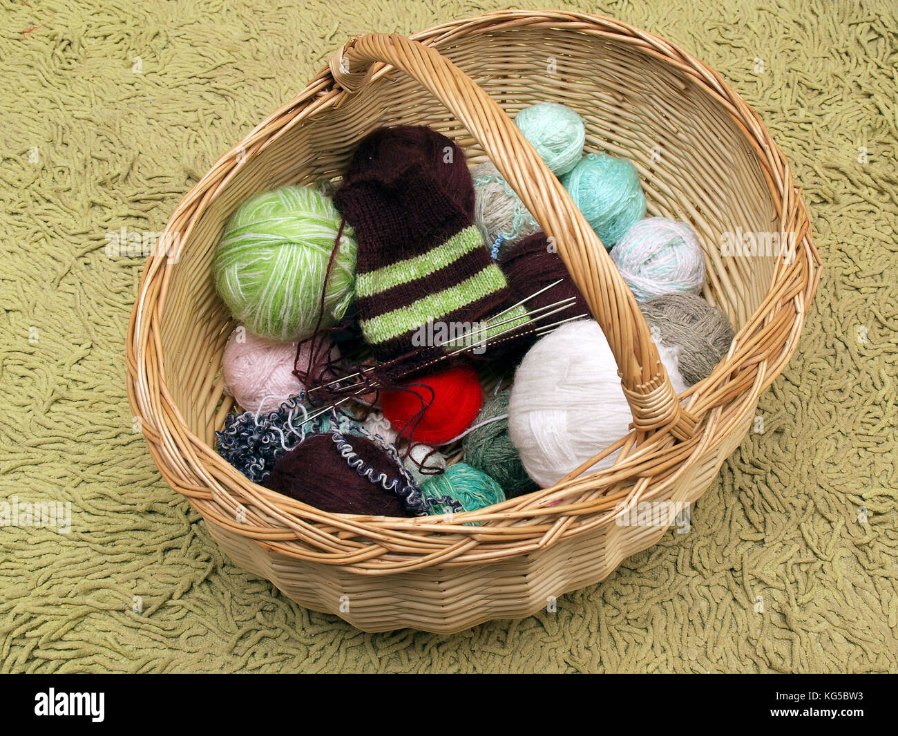 Wicker basket with knitting and yarn balls Stock Photo - Alamy