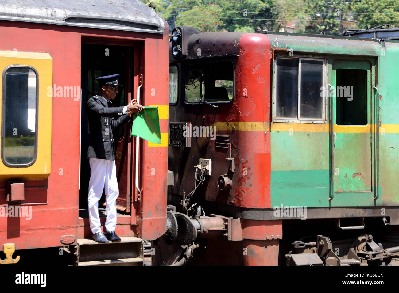 Peradeniya Junction Station Kandy Central Province Sri Lanka Guard on train signalling with green flag Stock Photo