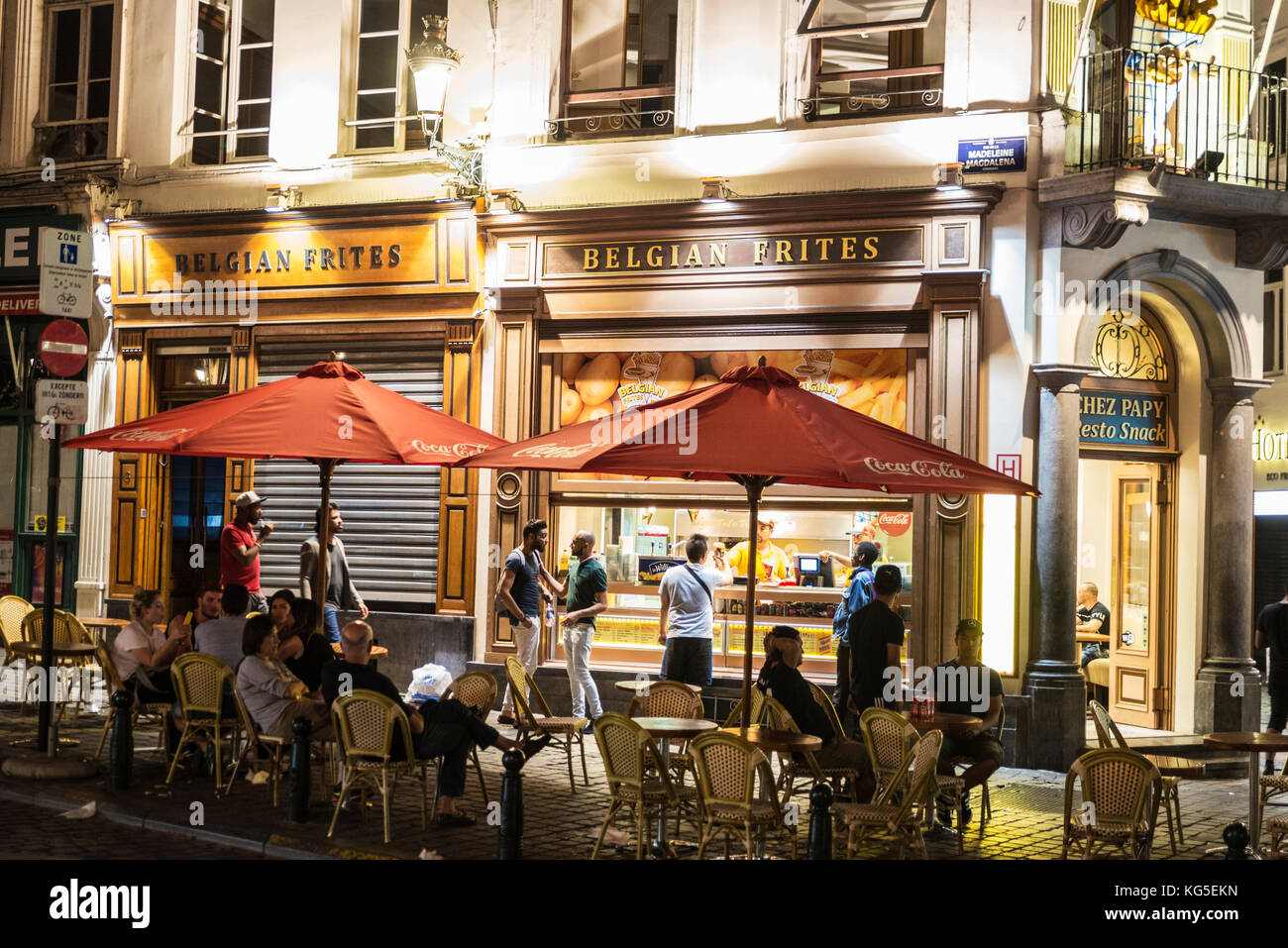Brussels, Belgium - August 27, 2017: Street with a bar or restaurant specialized in chips with people at night located in the historic center of Bruss Stock Photo
