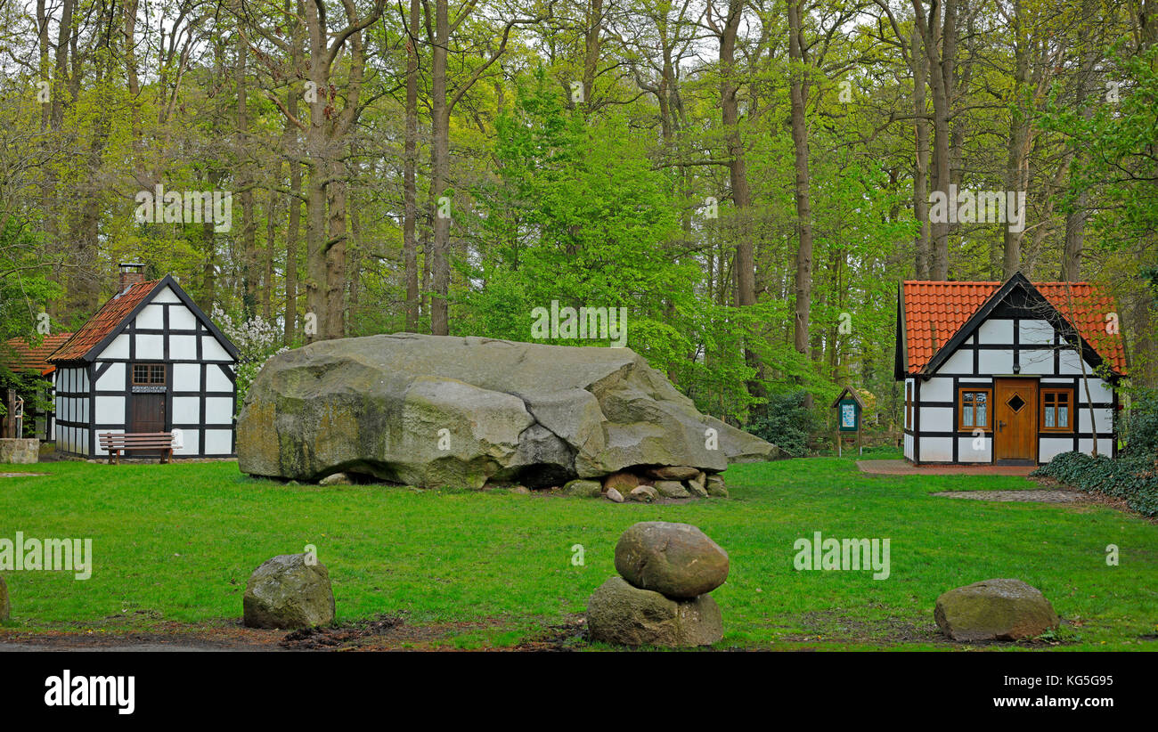 the big erratic block of Tonnenheide in an oak forest with half-timbered houses on Westfälischen Mühlenstraße (route), Germany, administrative district of Minden-Lübbecke Stock Photo