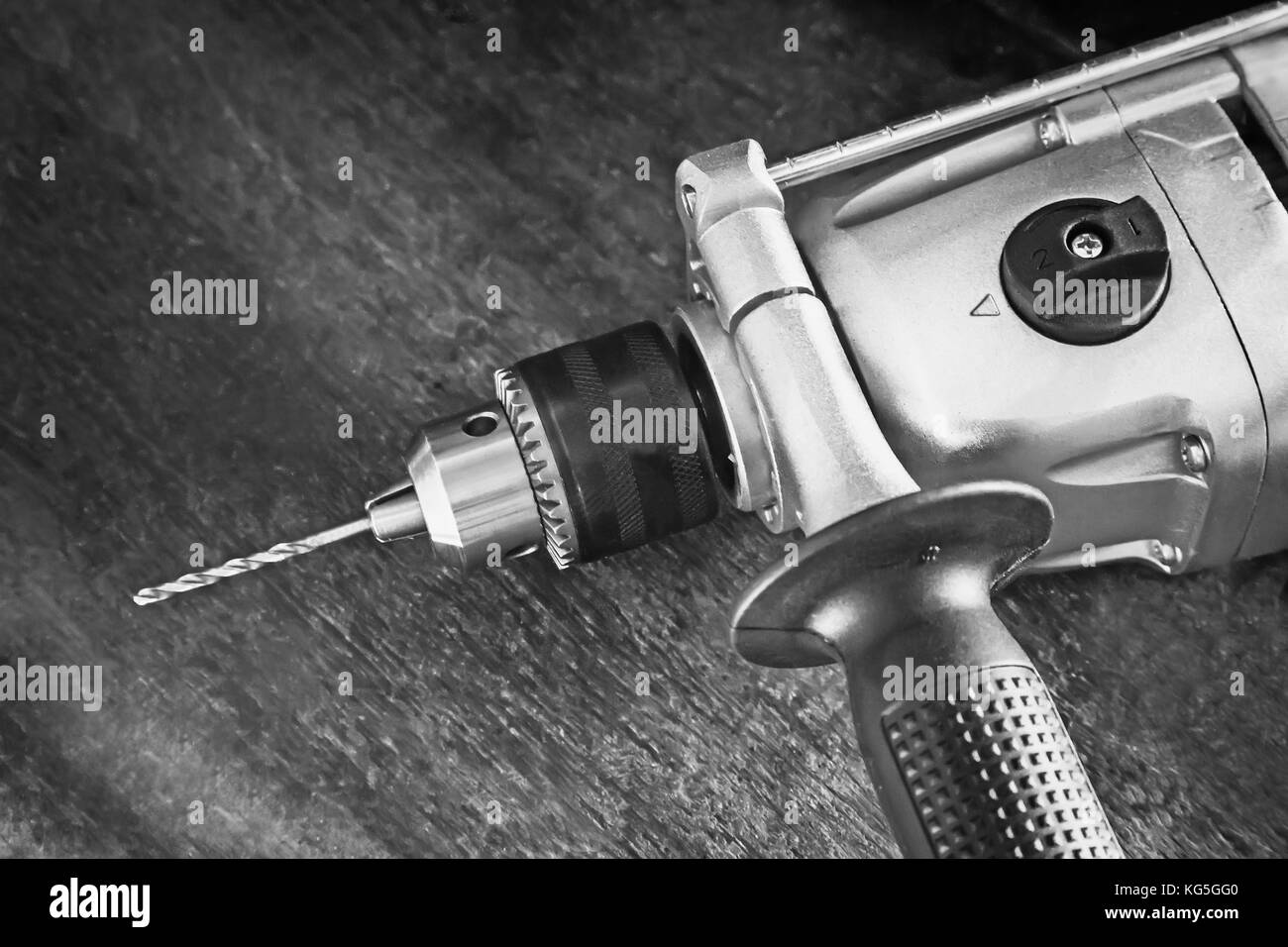 On a carpenter's workbench lies a compact electric hand drill Stock