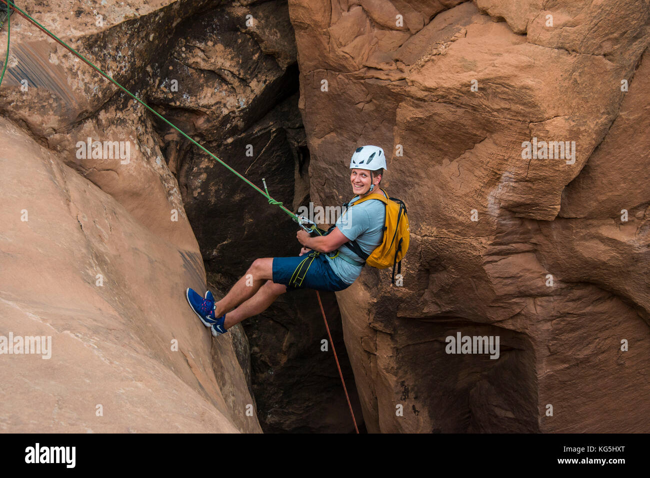 Man rapelling down in slot canyon, Canyonering, Moab, Utah, USA Stock Photo