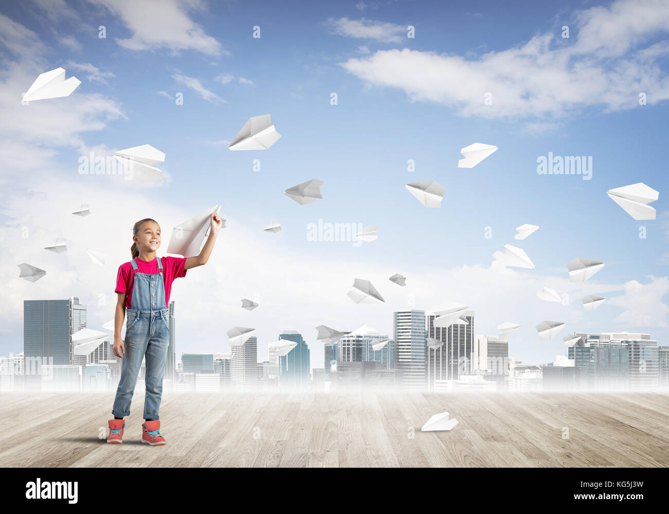 Cute kid girl stand on wooden floor and paper planes flying around ...