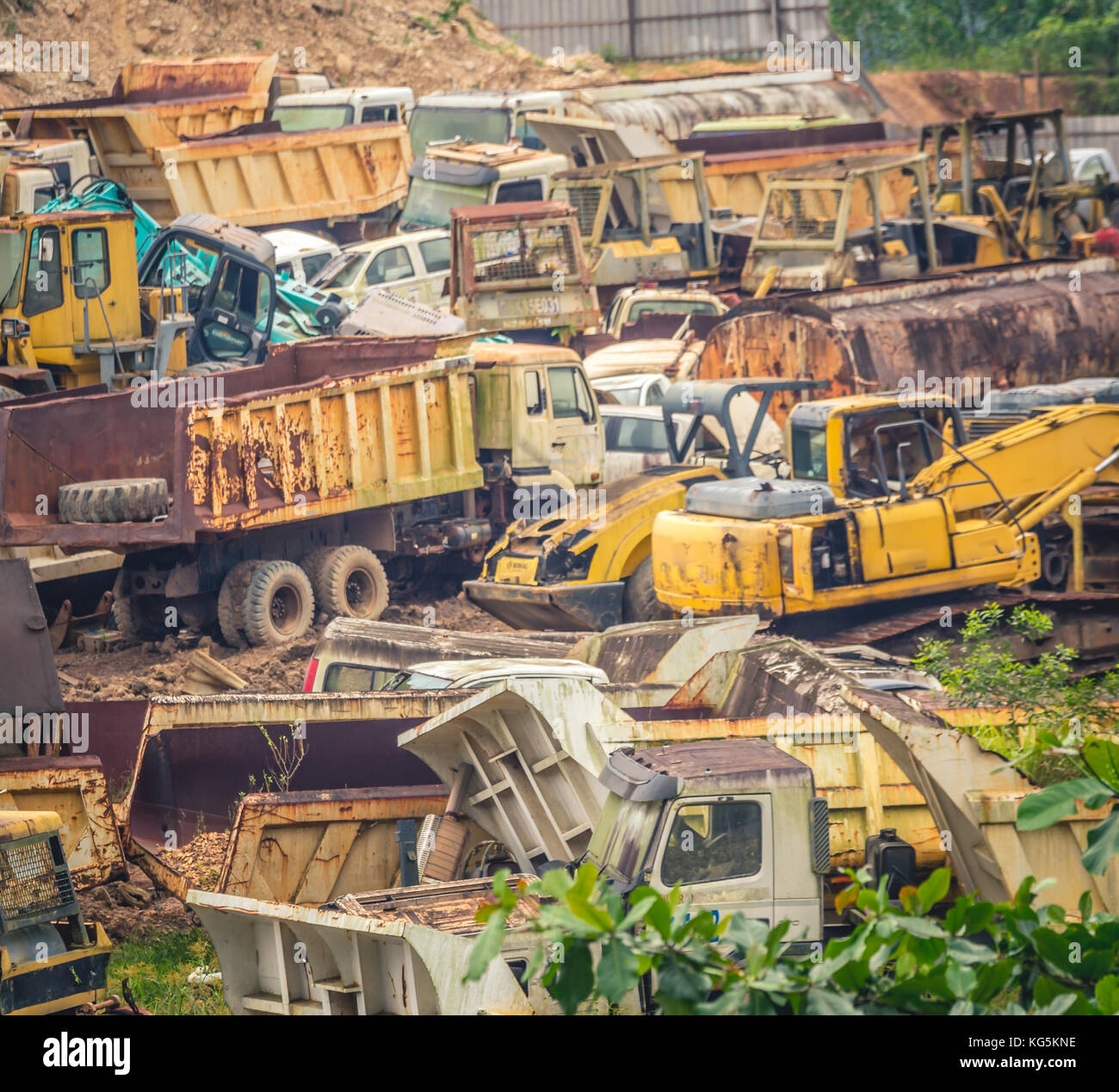 Junkyard full of colorful heavy machinery in the valley surrounded by vegetation Stock Photo Alamy