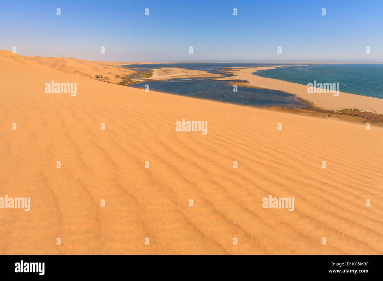 Sand dunes modeled by wind meet the Atlantic Ocean and lagoons in Walvis Bay Namib Desert Erongo Region Namibia Southern Africa Stock Photo