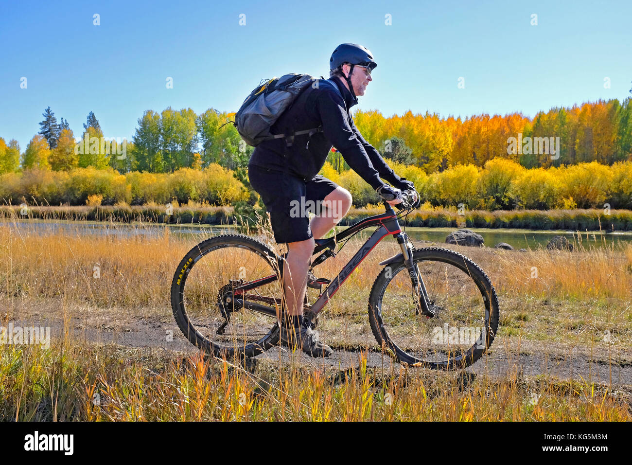 A bicyclist rides along the Deschutes River Trail , on the Deschutes
