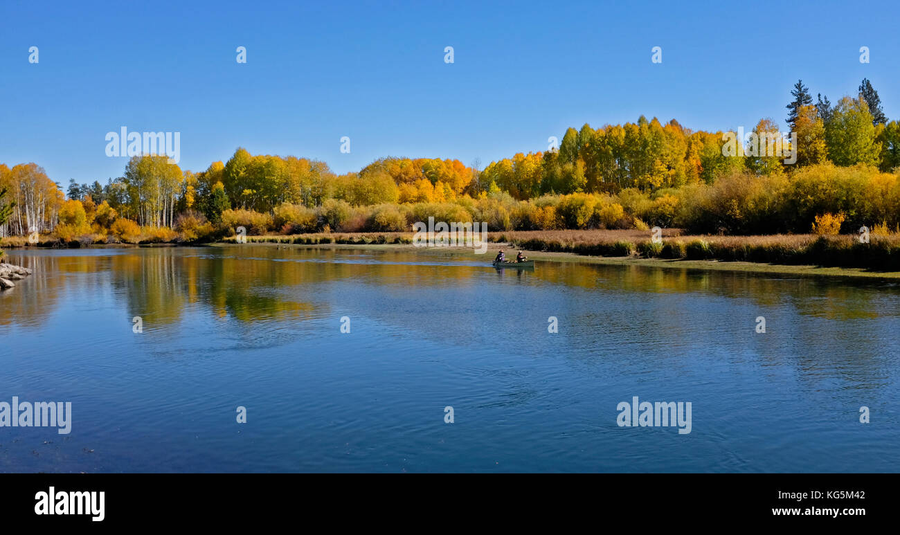 Two people float along the Deschutes River Paddle Trail in a canoe, on the Deschutes river near