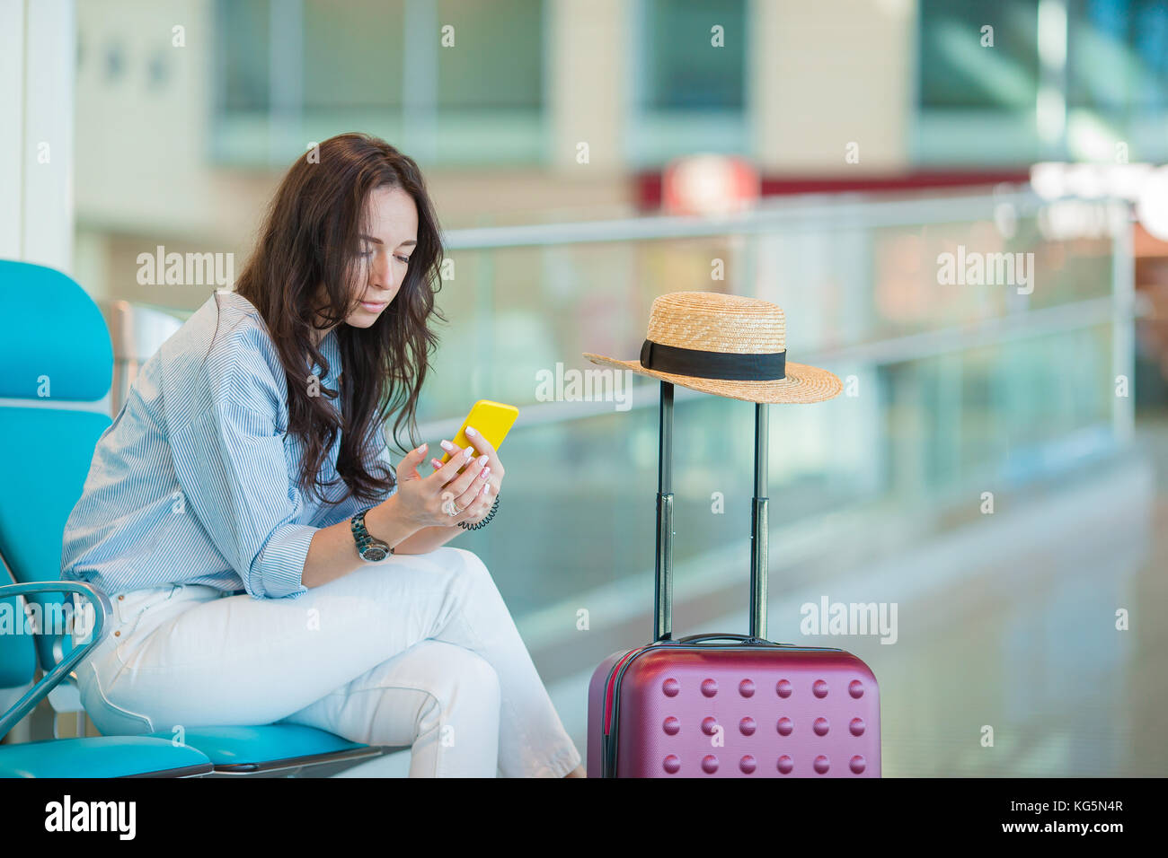 Young woman in international airport walking with her luggage Stock ...