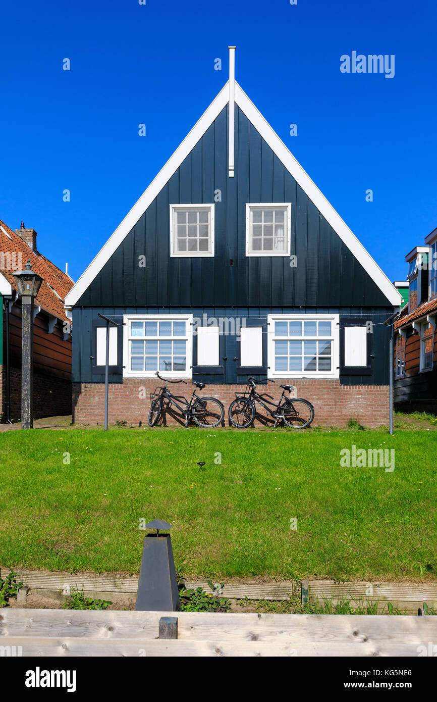 Typical wooden house surrounded by green gardens and bicycles Marken Waterland North Holland The Netherlands Europe Stock Photo