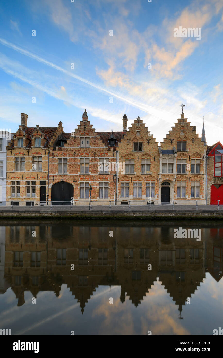 Bright sky at dawn on historic buildings of the city centre reflected in the typical canal Bruges West Flanders Belgium Europe Stock Photo